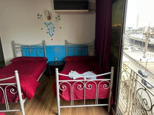 two beds in a room with a balcony at oasis Hotel in Cairo
