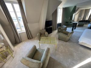 a large living room with a bed and chairs at Logis Hotel La Maison à Pan De Bois in Vierzon