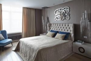 a bedroom with a large bed and a blue chair at ATRIA Mega Almaty in Almaty