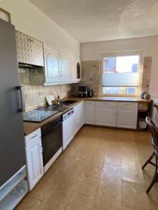 a kitchen with white cabinets and a stove top oven at Casa Pippi Lotta in Gießen +14 photos