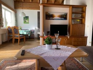 ein Wohnzimmer mit einem Tisch und einem Glas Wein in der Unterkunft Ferienwohnungen Wörz, Sigismundstrasse 6 in Oberstdorf