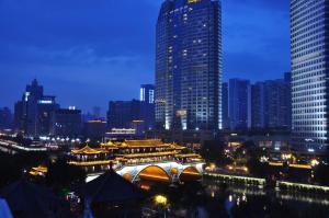 a city skyline at night with a tall building at H-hotel Riverside in Chengdu