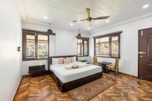 Un dormitorio con una cama y un ventilador de techo. en Alaya Stays Madhuram Pet-Friendly Hillside Retreat With Garden & Balcony, en Dehradun
