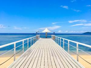 drewniany pomost z parasolem na plaży w obiekcie Holistic retreat Coco w mieście Ishigaki