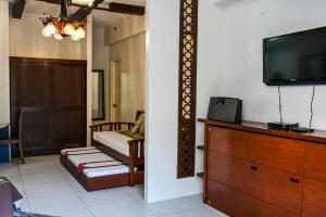 ein Wohnzimmer mit einem TV und einer Kommode in der Unterkunft Jacana A 1BR Pico de Loro by PTours in Nasugbu