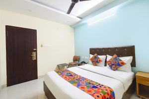 a bedroom with a large bed with colorful pillows at Hotel L Grand - Nr Secunderabad Railway Station in Hyderabad +25 photos