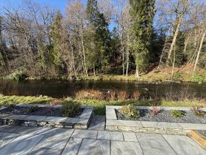 a garden with two steps next to a river at Greta House in Keswick