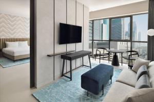 a living room with a couch and a tv at Courtyard by Marriott World Trade Centre, Dubai in Dubai