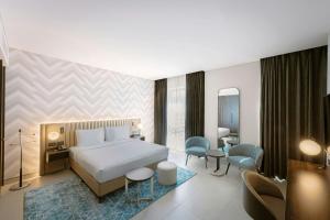 a bedroom with a bed and a living room at Courtyard by Marriott World Trade Centre, Dubai in Dubai