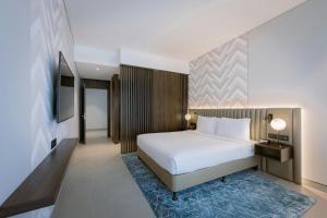 a hotel room with a bed and a television at Courtyard by Marriott World Trade Centre, Dubai in Dubai