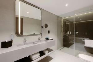 a bathroom with two sinks and a mirror and a shower at Courtyard by Marriott World Trade Centre, Dubai in Dubai