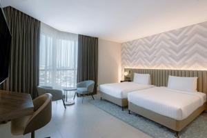 a hotel room with two beds and a desk at Courtyard by Marriott World Trade Centre, Dubai in Dubai