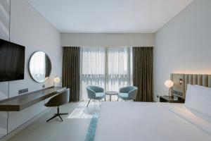 a hotel room with a bed and a desk and chairs at Courtyard by Marriott World Trade Centre, Dubai in Dubai