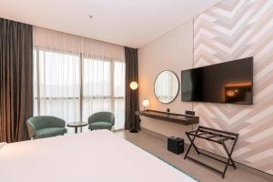 a hotel room with a bed and a desk and a television at Courtyard by Marriott World Trade Centre, Dubai in Dubai