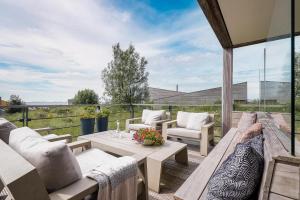 a patio with a couch and a table and chairs at Exclusive Duin Villa - 6p - Direct bij Natuur & Strand - Villa 70 in Ouddorp
