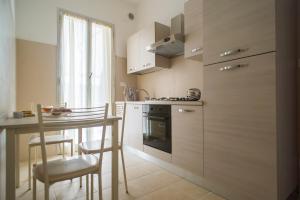 a kitchen with a stove and a table with chairs at Casa Damiano in Faenza
