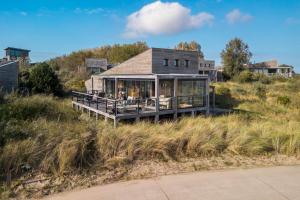a house sitting on top of a grassy hill at Panorama Beach Villa 4p - Premium Comfort & Uitzicht - Villa 25 in Ouddorp
