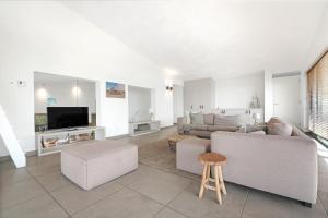 a living room with a couch and a tv at Beachfront VIP Villa - 4p - Luxe & Strand op 50m - Villa 59 in Ouddorp