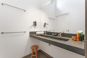 a bathroom with two sinks and a wooden stool at Beachfront VIP Villa - 4p - Luxe & Strand op 50m - Villa 59 in Ouddorp +48 photos