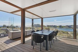a dining room with a table and chairs on a deck at Luxe Villa met Uitzicht 4p - Luxe, Rust & Water - Villa 67 in Ouddorp