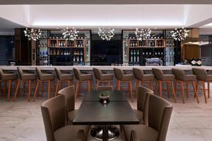a dining room with a table and chairs and a bar at AC Hotels by Marriott Guatemala City in Guatemala