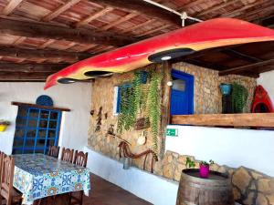 a room with a table and a surfboard on the wall at La cuadra de Juan in Icod de los Vinos