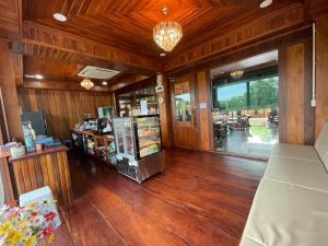 a room with wooden floors and a store with a counter at Ruen Singhanat Cafe & Resort in Ban Lum Thonglang (2)
