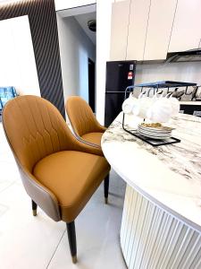 ジョホールバルにあるDeluxe 3 Bedroom Garden Viewのカウンターの椅子2脚付きキッチン