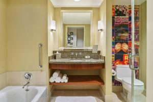a bathroom with a sink and a tub and a toilet at Renaissance Las Vegas Hotel in Las Vegas