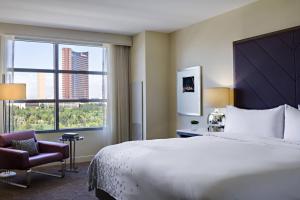 a hotel room with a large bed and a chair at Renaissance Las Vegas Hotel in Las Vegas