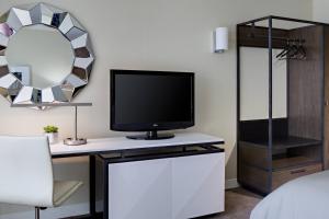 a room with a tv on a desk with a mirror at Renaissance Las Vegas Hotel in Las Vegas