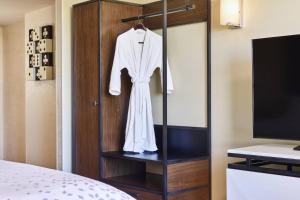 a white robe hanging on a wooden cabinet in a bedroom at Renaissance Las Vegas Hotel in Las Vegas