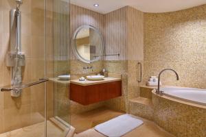 a bathroom with a sink and a tub and a mirror at Renaissance Las Vegas Hotel in Las Vegas