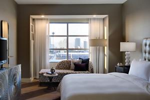 a hotel room with a bed and a couch and a window at Renaissance Las Vegas Hotel in Las Vegas