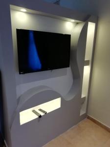 a flat screen tv on a wall in a room at شقه مفروشه دوبلكس من غرفتين نوم حى العليا الخبر in Al Khobar +13 photos