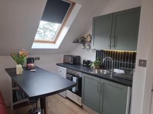 a kitchen with a black counter top and a sink at The Loft at 522 in Woodburn