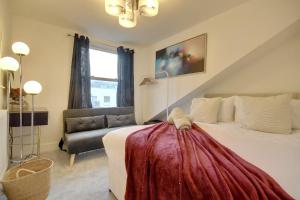a bedroom with a large bed and a couch at Top Floor Apartment in Portsmouth