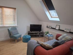 a living room with a red couch and a tv at The Loft at 522 in Woodburn