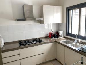 a white kitchen with a sink and a stove at Appartement F3 Point E Cosy et Spacieux in Dakar
