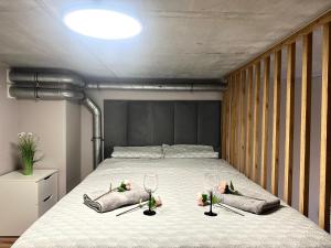 una camera da letto con un letto con due bicchieri e fiori sopra di Zarembowicza Apt 52 - Self Check-In 20h - Lift a Breslavia