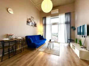 un soggiorno con un divano blu e un tavolo di Zarembowicza Apt 52 - Self Check-In 20h - Lift a Breslavia
