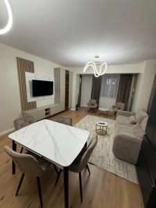 a living room with a white table and a couch at Sole Central Apartment in Râmnicu Vâlcea +4 photos