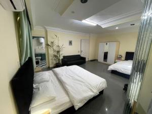 a bedroom with a white bed and a couch at Xibei Lou Hotel 西北楼华人宾馆 in Cairo