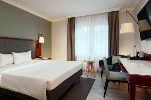 a hotel room with a bed and a desk at Courtyard by Marriott Hamburg Airport in Hamburg