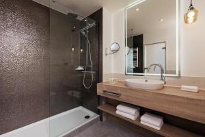 a bathroom with a sink and a shower at Courtyard by Marriott Hamburg Airport in Hamburg