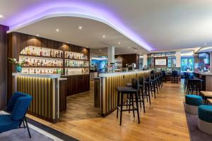 a bar in a restaurant with chairs and tables at Courtyard by Marriott Hamburg Airport in Hamburg