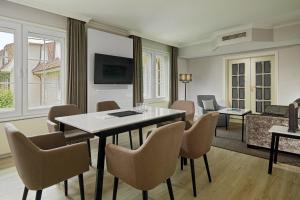 a living room with a table and chairs at Courtyard by Marriott Hamburg Airport in Hamburg