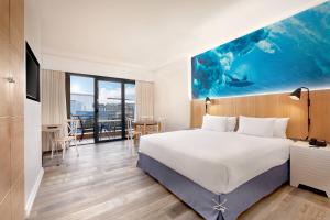 a hotel room with a large bed and a table at Protea Hotel Fire & Ice! by Marriott Durban Umhlanga Ridge in Durban