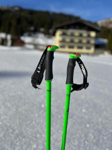 two green and black golf clubs sitting on a street at Hotel Bergglück in Filzmoos