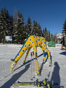 a statue of a giraffe standing in the snow at Hotel Bergglück in Filzmoos
